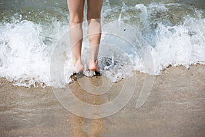 Young girl legs in sea surf