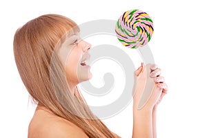 Young girl licks lollipop