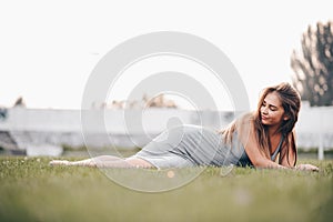 A young girl lies on the grass like a goddess and looks into nowhere. Day off concept