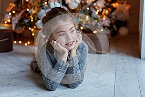 Young girl lies near a Christmas tree