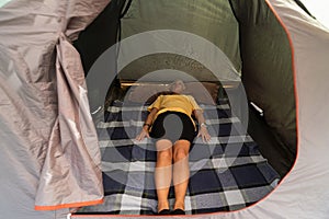 A young girl lies in a tent in nature, close-up photo