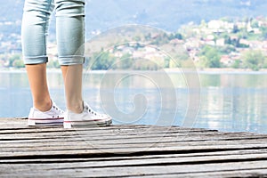 Young girl lies on a wooden pier in front of the lake