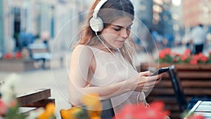 Young girl listen to music on the bench