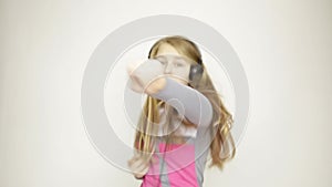 Young girl listening music on headphones and funy dancing