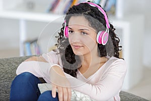 young girl listening to headphones in home