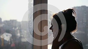 A young girl listening to her favorite music on headphones from the phone, dancing, jumping and singing against the