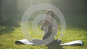 Young girl listening to music while doing sports in the park. Healthy lifestyle concept