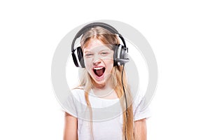 Young girl listening to music with headphones over white