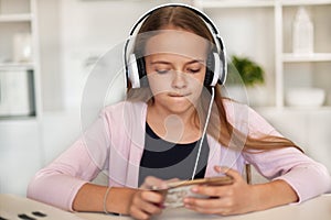 Young girl listening to music on her phone and headset