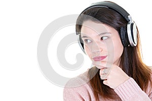 Young girl listening to music pensive dreaming in headphones and looking side copy space