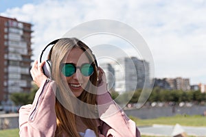Young girl listens to music in a park in the city