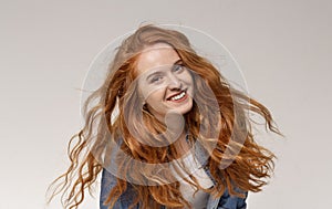 Young girl with long beautiful ginger hair smiling to camera