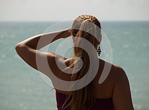 Young girl with long hair looks at the sea