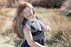 Young girl with long red hair against an autumnal natural background