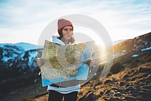 Young girl look and hold in hands map, people planning trip, hipster tourist on background sun flare nature, enjoy journey land