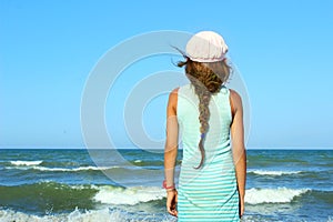 Young Girl Looking On A Calm Sea And Blue Skies, Back View.