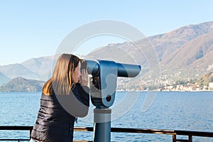 Young girl looking through a coin operated binoculars. Bellagio
