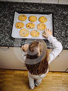 Young girl looking at freshly baked cookies