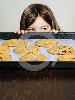 Young girl looking at freshly baked cookies