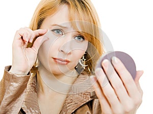 Young girl is looking at herself in mirror