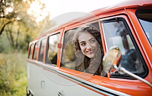 A young girl looking out of a car on a roadtrip through countryside.