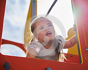 Young Girl Looking out from Play Equipment, Smiling