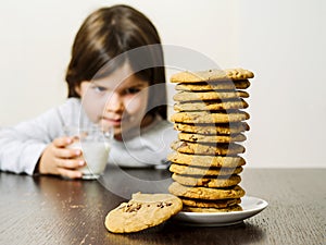 Young girl looking at a stack of cookies