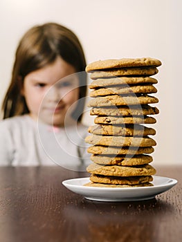 Young girl looking at a stack of cookies