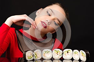 Young girl looking on sushi rolls