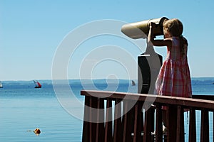 Young girl looking through telescope