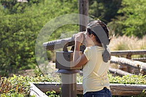 Young girl looking through telescope