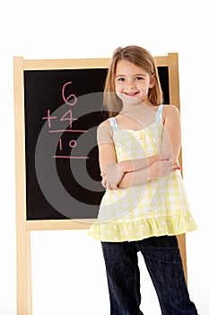 Young Girl Looking Thoughtful Next To Blackboard