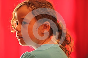 Young Girl Looking to the Side in Red Background