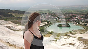 Young girl looking on travertine pools and terraces in Pamukkale.