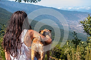 Young girl looks at the landscape with her dog