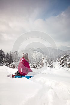 Young girl looks at mountains in winter