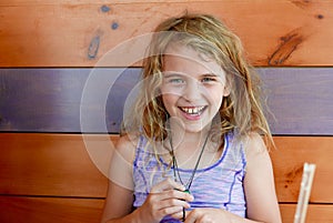 Young girl luaghing and smiling at the camera in a wooden restaurant booth