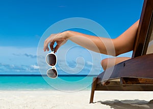 Young girl lying on a beach lounger with glasses in hand photo