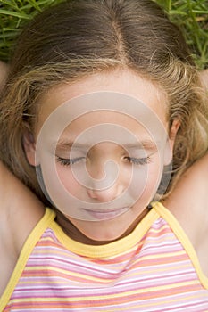 Young Girl Lying Down On The Grass