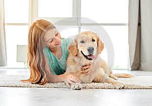 Young girl lying with golden retriever