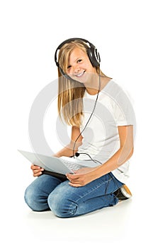 Young girl lying on the floor listening to music over white back