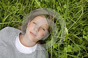 Young girl lying in the grass dreaming of ...