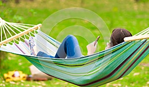 Young girl lying on a hammock with cell phone