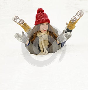 Young girl lying in the snow and laughs