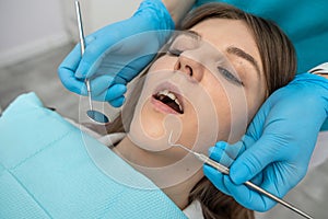 young girl lying in a woman& x27;s dentist chair on a dental examination.