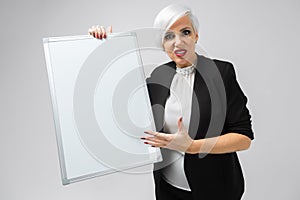 Young girl with a magnetic Board in her hands stands isolated on a light background