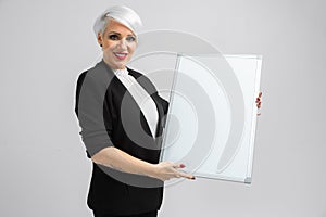 Young girl with a magnetic Board in her hands stands on a light background