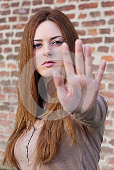 Young girl making stop gesture with her hand, selective focus