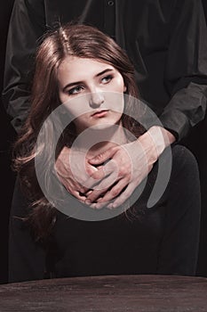 Young girl and male hands on a black background