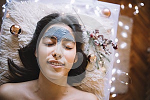 Young girl with mask on forehead relaxing at SPA